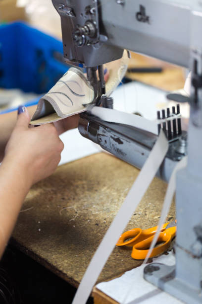 istock Woman shoemaker sewing flip flops on dedicated machine 848631160