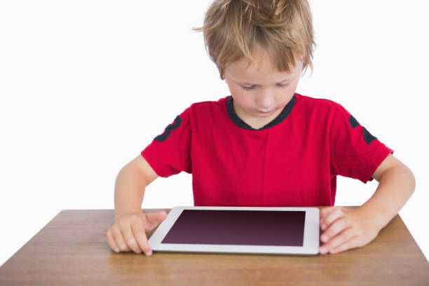 istock Little boy sitting at desk and looking at digital tablet 848650558