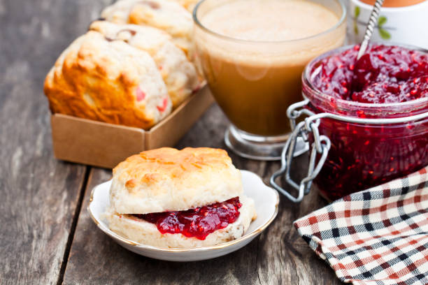 Traditional  scone with raisins filled raspberry jam and cup of coffee