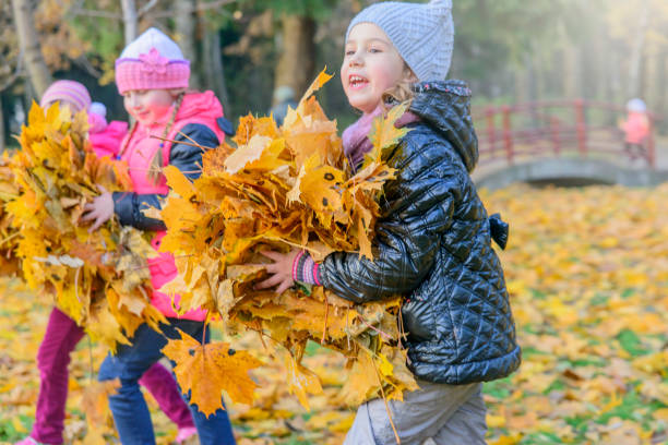 istock Children play in autumn Park.Falling leaves from trees. 848658496