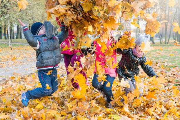istock Children play in autumn Park.Falling leaves from trees. 848658642