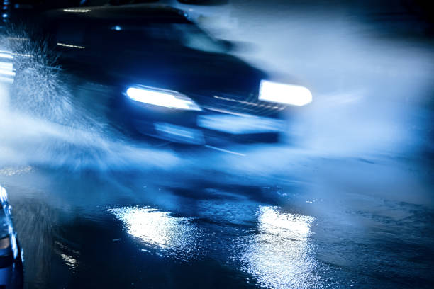 istock water splashes and blue headlights reflecting in puddles. motion blur. 848662546