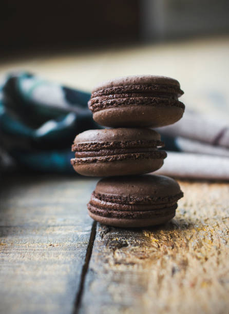 istock Fresh baked chocolate macarons on wooden texture 848667250