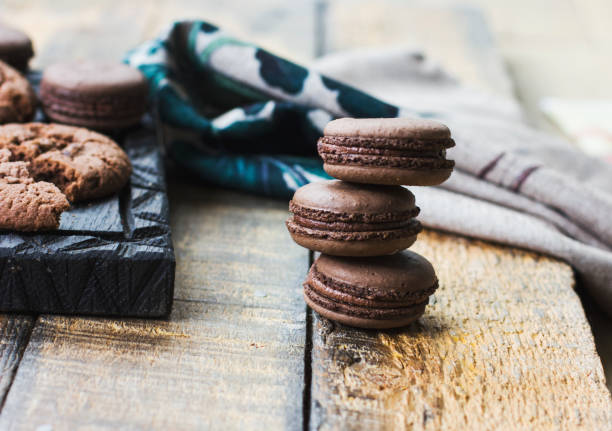 istock Fresh baked chocolate macarons on wooden texture 848667252