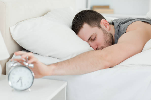 istock Sleeping man being awakened by an alarm clock 848671862