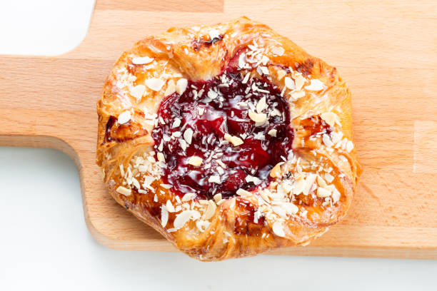 Open pies of Puff pastry pies with with honey, berries and nuts . Puff pastry pies with with honey, berries and nuts . on white background. on wooden plate mark goodson screening room stock pictures, royalty-free photos & images