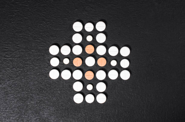 Round white tablets arranged into a decorative circle on red, abstract pharmaceutical background suitable for websites and banners.