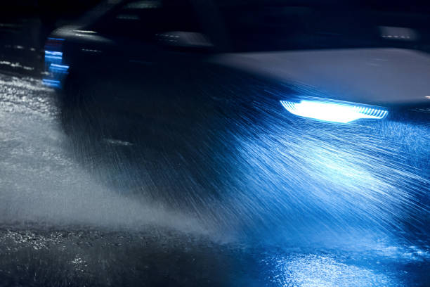 istock car spraying water as it drives during heavy rain at night 848682714