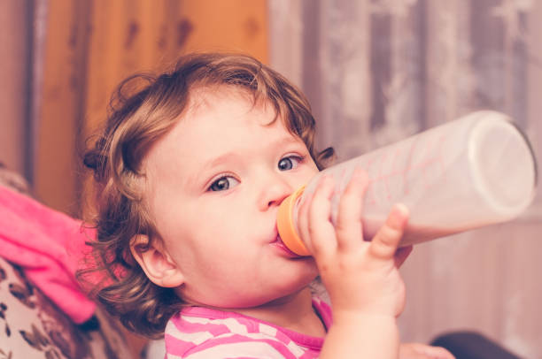 istock Little girl drinks milk from a bottle 848692228