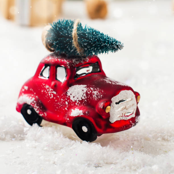 istock Miniature red car carrying fir tree on Christmas background 848695736