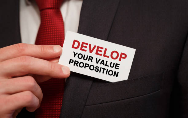 istock Businessman putting a card with text Develop your value proposition in the pocket 848701138