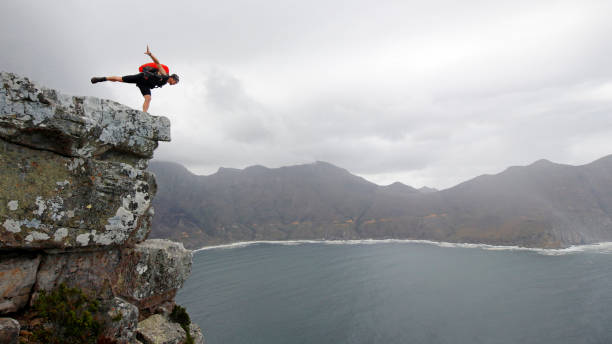 deportes extremos gente base-jumping toro de las montañas rojas de ardilla-suite escalada paracaídas al mar - salto desde acantilado fotografías e imágenes de stock