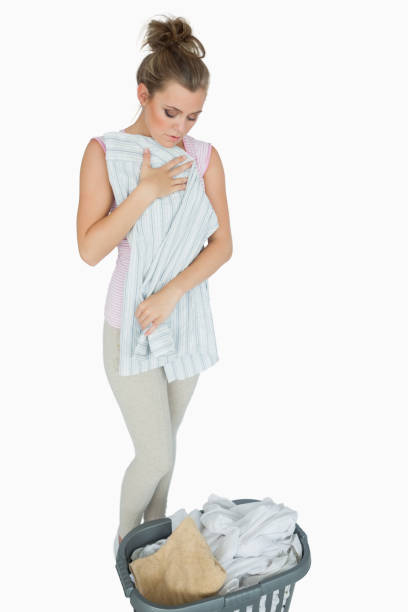 istock Young woman folding shirt with laundry basket 848712716