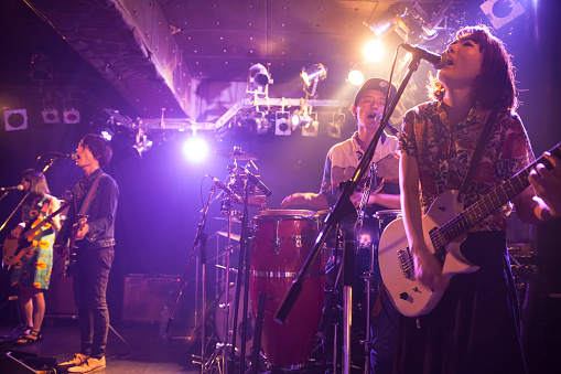 A rock music band is having a live concert in a bar in Tokyo.