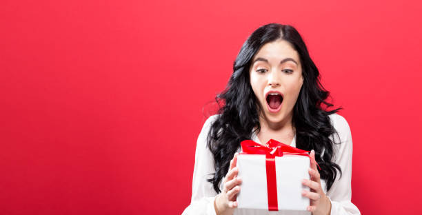 istock Happy young woman holding a gift box 848720946
