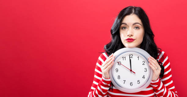 istock Woman holding clock showing nearly 12 848720970