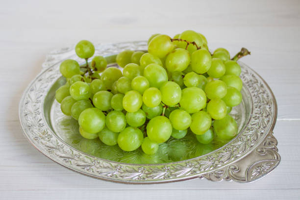 istock Green grapes in a dish on a white wooden background 848726840