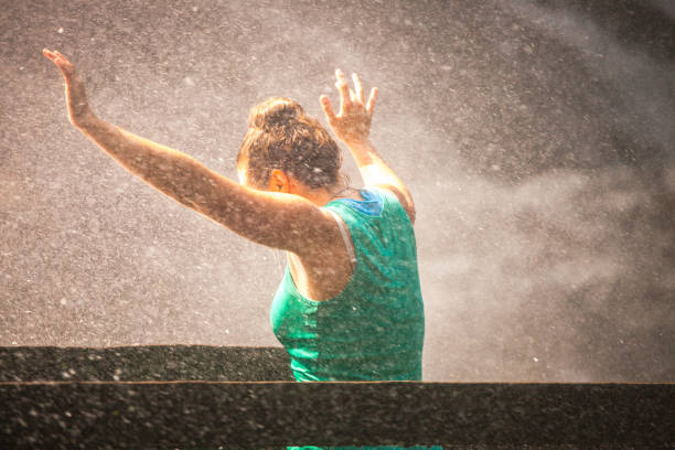 Young Woman standing and waving above the Simmen water fallls, Bernese Oberland, Switzerland