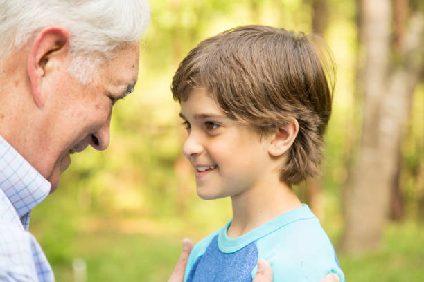 istock Grandfather and grandson face-to-face outdoors together. 848758988