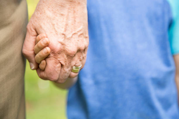istock Grandfather and grandson holding hands outdoors together. 848759186