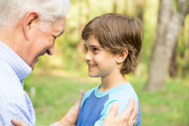 istock Grandfather and grandson face-to-face outdoors together. 848759624