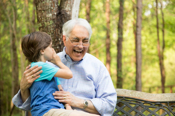 abuelo y nieto decir secretos al aire libre juntos. - whispering grandparent child grandfather fotografías e imágenes de stock
