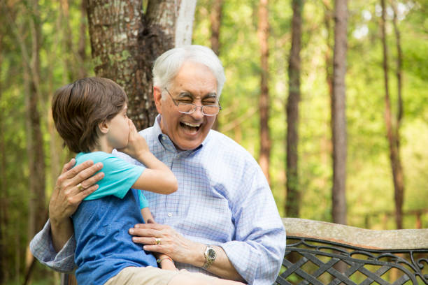 istock Grandfather and grandson tell secrets outdoors together. 848759722
