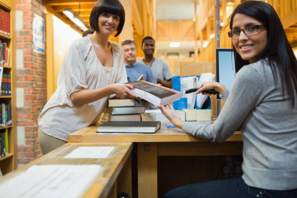 istock Librarian scanning book and handing to woman 848764596