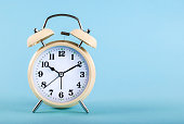 Old alarm clock isolated on a blue background with space for text