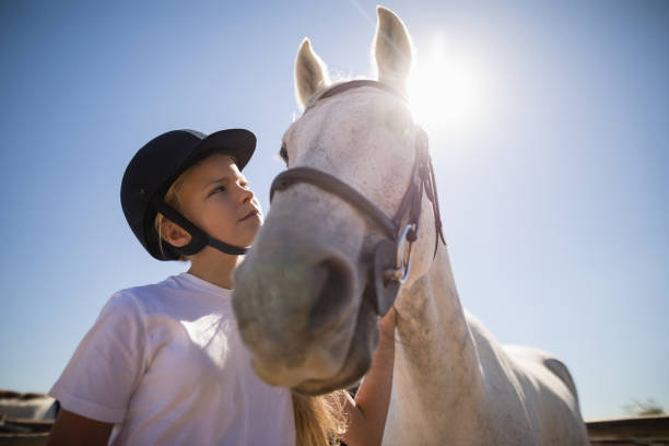 istock Rider girl looking at the white horse 848772412