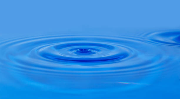 istock a drop of water falling in blue water. macro 848779356