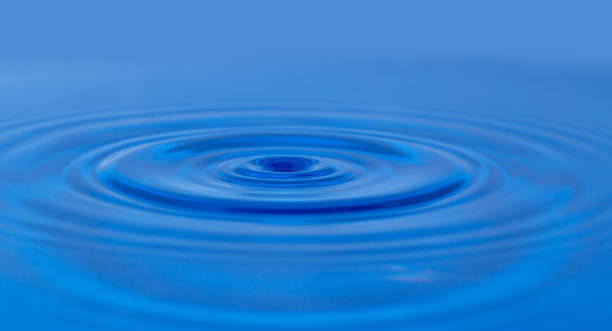 istock a drop of water falling in blue water. macro 848779492