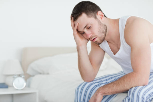 istock Tired young man sitting on his bed 848786618