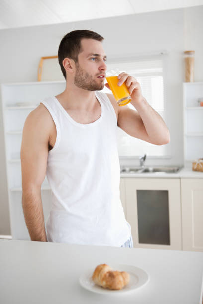 retrato de un hombre sano beber zumo de naranja - instructor one person fruit drinking fotografías e imágenes de stock
