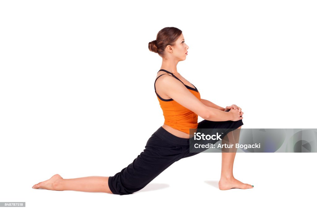 Fit Attractive Woman Practicing Yoga Stretching Pose Woman practicing first stage of yoga pose called Crescent Lunge, Sanskrit name: Anjaneyasana, this posture stretches the thighs, hamstrings, groins, hip, isolated on white Hamstring Stock Photo