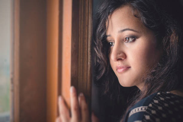 istock Serene young woman looking outside with blank expression. 848787634
