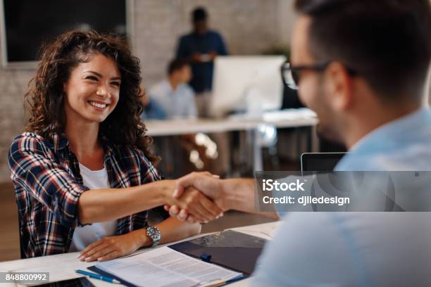 Young Woman Signing Contracts And Handshake With A Manager Stock Photo - Download Image Now