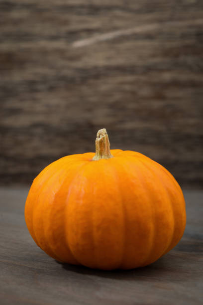 istock seasonal ripe pumpkin on a wooden table, vertical 848813770