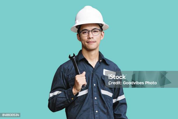 Asian Manengineer Or Technician In White Helmet Glasses And Blue Working Shirt Suit Holding Wrench Isolated On Green Mechanic And Oil And Gas Industrial Concept With Clipping Path Stock Photo - Download Image Now