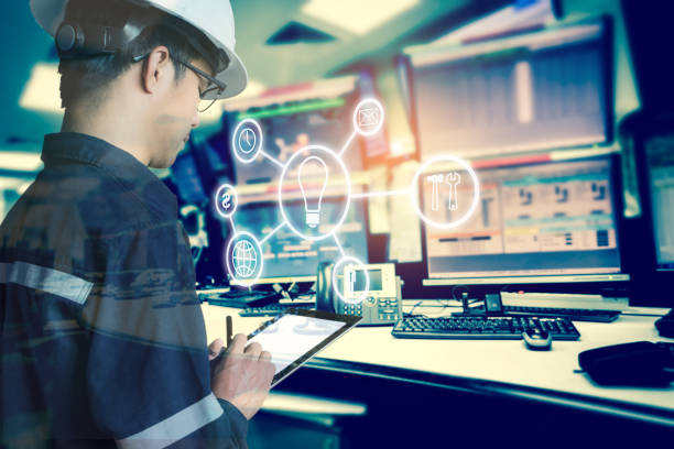 Double exposure of Engineer or Technician man with business industrial tool icons while using tablet with monitor of computers room  for oil and gas industrial business concept. stock photo