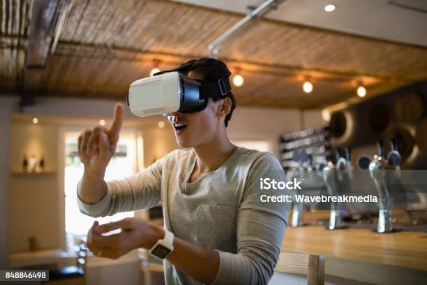 Hombre Con Casco De Realidad Virtual En Restaurante Foto de stock y más banco de imágenes de Simulador de realidad virtual