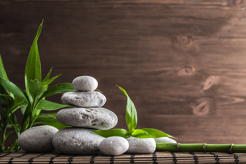 zen balance stones and bamboo plant on the straw mat