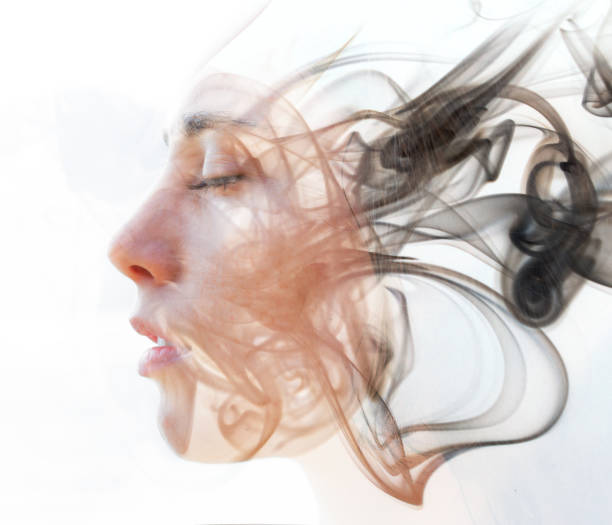 Double exposure portrait of a young fair-skinned woman and a smoky texture dissolving into her facial features D:"n"nWe see through the make up of her skin in a seemingly transparent veil of her being hypnosis stock pictures, royalty-free photos & images
