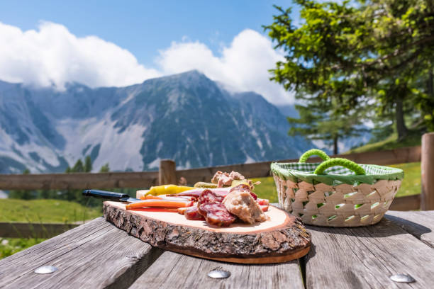 brettljause su tavolo di legno con vista sulla catena montuosa karawanks - austria summer mountain european alps foto e immagini stock