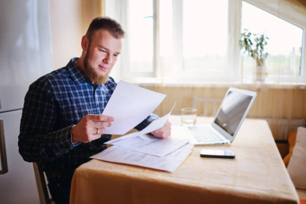 istock Businessman at home, he is working with a laptop, checking paperwork and bills 848872910
