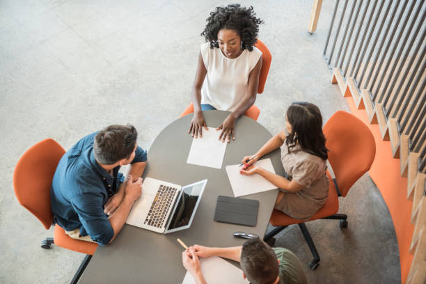 istock Four business people sitting in modern office having meeting 848878204