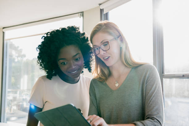 istock Two young businesswomen in office using tablet 848878272