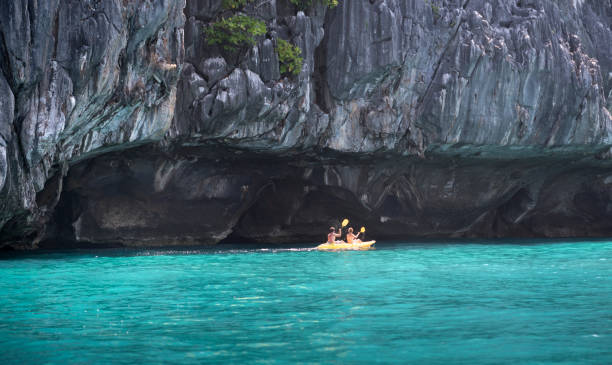 casal explorar cavernas de caiaque, ilhas phi phi, tailândia - railay - fotografias e filmes do acervo