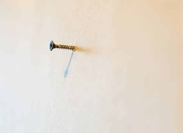 istock A small screw is screwed into a gypsum plasterboard ( drywall) wall in the house is under construction, remodeling, rebuilding and renovation. 848884866