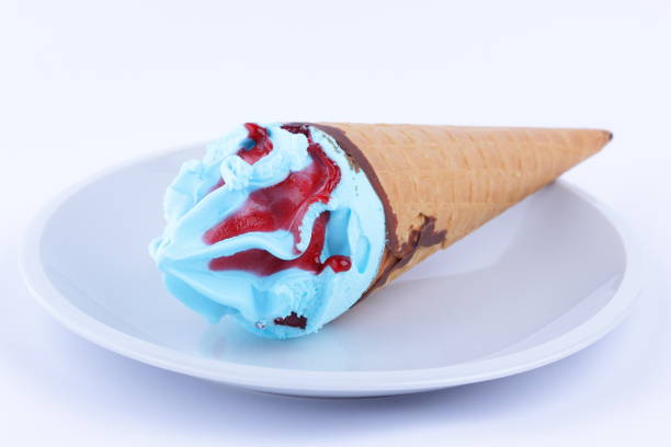 istock Ice cream in a waffle cup with blue stuffing and red jam on a white plate for designer 848898128